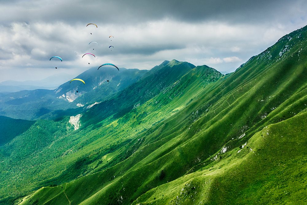 Gleitschirm fliegen mit Bergen im Hintergrund